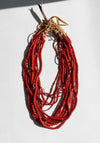 Red beaded necklace on a white background