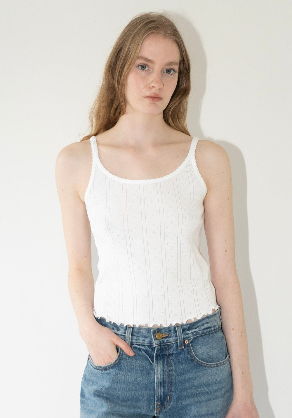 Róhe Pointelle Tank in Off White. A classic tank top crafted from pointelle cotton, finished with a delicate lettuce-edge hem for subtle texture.